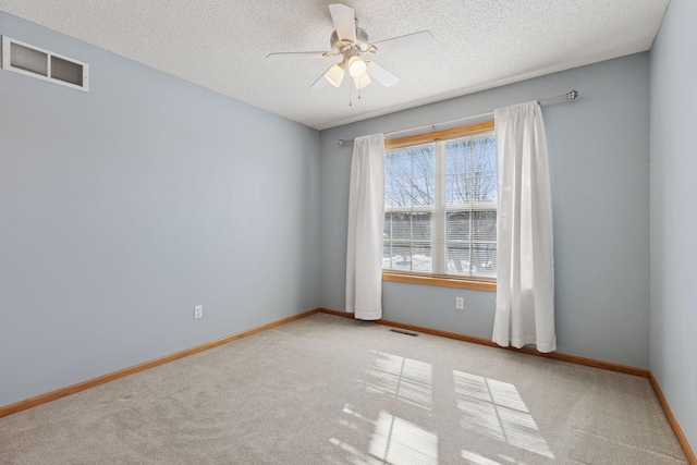 spare room featuring visible vents, baseboards, and a textured ceiling