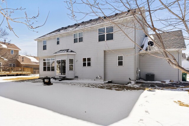 snow covered house featuring entry steps and a deck