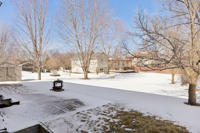 yard layered in snow with an outdoor structure and a shed