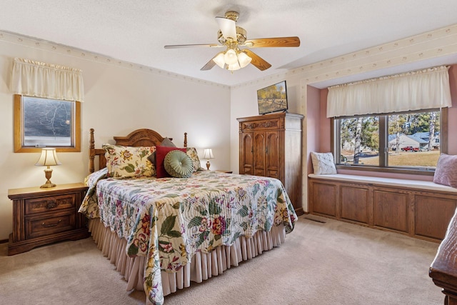 bedroom featuring light carpet, ceiling fan, and a textured ceiling