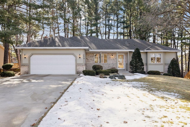 single story home featuring a garage, driveway, and brick siding