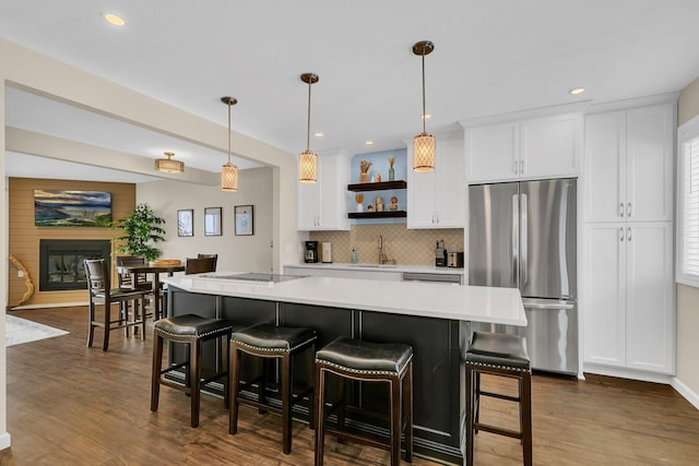 kitchen featuring a sink, white cabinets, light countertops, freestanding refrigerator, and open shelves