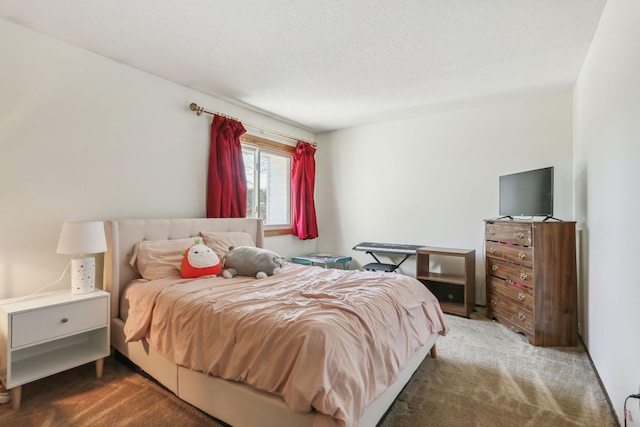 bedroom with a textured ceiling and dark carpet