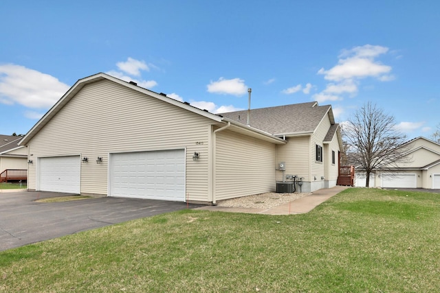 13413 Pine View Pl, Lindstrom, MN 55045 - view of side of property with a lawn, an attached garage, asphalt driveway, and roof with shingles