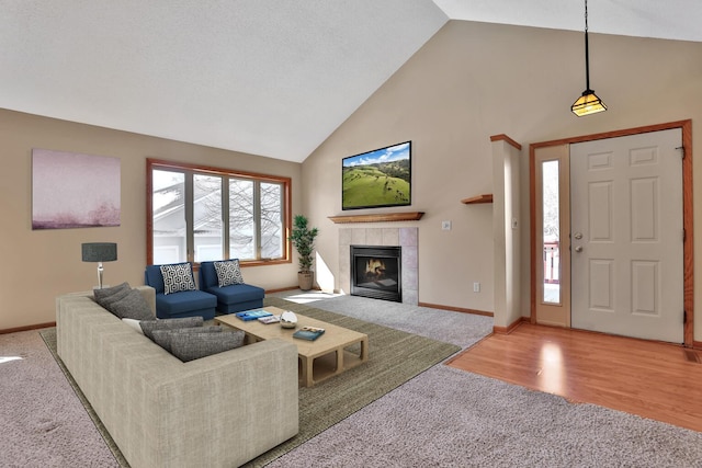 13413 Pine View Pl, Lindstrom, MN 55045 - carpeted living room featuring high vaulted ceiling, a tiled fireplace, and baseboards