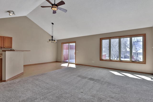 13413 Pine View Pl, Lindstrom, MN 55045 - unfurnished living room featuring light colored carpet, vaulted ceiling, ceiling fan, baseboards, and a chandelier