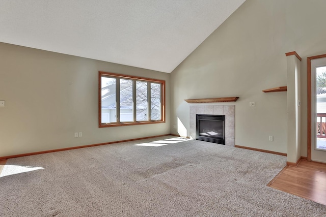 13413 Pine View Pl, Lindstrom, MN 55045 - unfurnished living room with carpet flooring, high vaulted ceiling, healthy amount of natural light, a tile fireplace, and baseboards