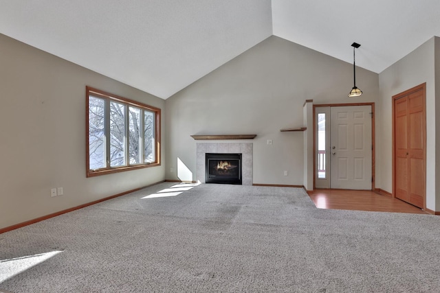 13413 Pine View Pl, Lindstrom, MN 55045 - unfurnished living room with carpet floors, a tile fireplace, high vaulted ceiling, and baseboards