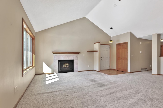 13413 Pine View Pl, Lindstrom, MN 55045 - unfurnished living room with carpet floors, a tile fireplace, high vaulted ceiling, and baseboards