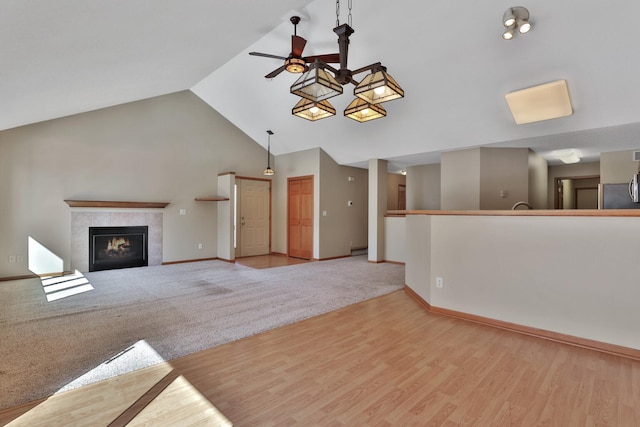 13413 Pine View Pl, Lindstrom, MN 55045 - unfurnished living room with ceiling fan, baseboards, a tile fireplace, wood finished floors, and high vaulted ceiling