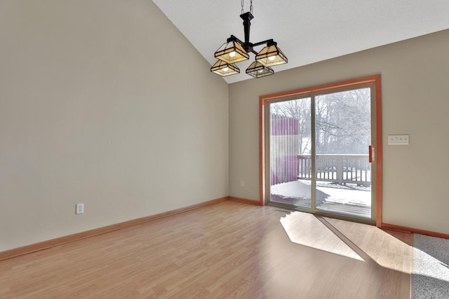 13413 Pine View Pl, Lindstrom, MN 55045 - spare room with lofted ceiling, a chandelier, light wood finished floors, and baseboards