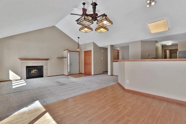 13413 Pine View Pl, Lindstrom, MN 55045 - unfurnished living room featuring ceiling fan, baseboards, a tile fireplace, wood finished floors, and high vaulted ceiling