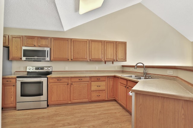 13413 Pine View Pl, Lindstrom, MN 55045 - kitchen featuring stainless steel appliances, a sink, lofted ceiling, light countertops, and light wood-type flooring