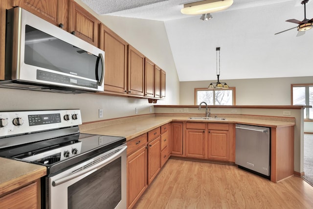 13413 Pine View Pl, Lindstrom, MN 55045 - kitchen featuring a sink, a peninsula, appliances with stainless steel finishes, vaulted ceiling, and light wood-style floors