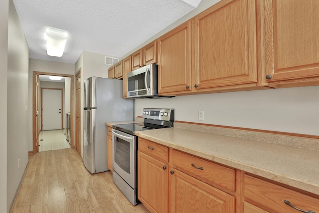 13413 Pine View Pl, Lindstrom, MN 55045 - kitchen featuring stainless steel appliances, light wood-style floors, light countertops, and a textured ceiling