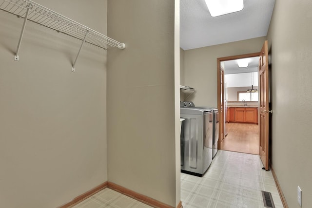 13413 Pine View Pl, Lindstrom, MN 55045 - clothes washing area featuring washer and clothes dryer, light flooring, and baseboards