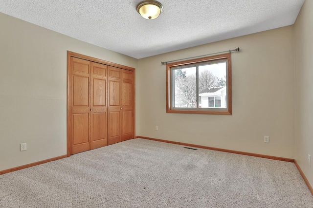 13413 Pine View Pl, Lindstrom, MN 55045 - unfurnished bedroom with carpet flooring, a closet, baseboards, and a textured ceiling