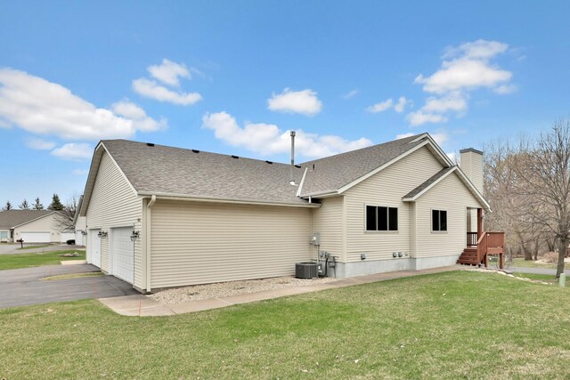 13413 Pine View Pl, Lindstrom, MN 55045 - rear view of property with a yard, a chimney, a garage, central AC, and roof with shingles