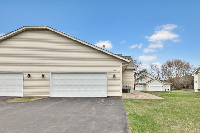 13413 Pine View Pl, Lindstrom, MN 55045 - view of side of property featuring a garage, a lawn, asphalt driveway, and central AC unit