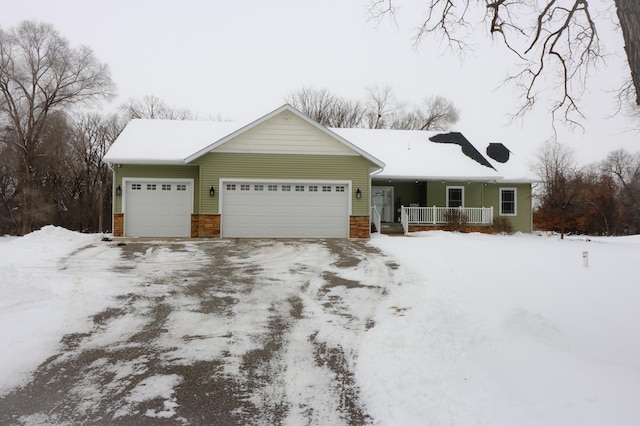 single story home featuring a garage, covered porch, and driveway