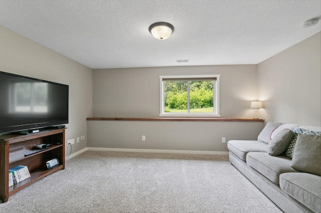 carpeted living area featuring baseboards, visible vents, and a textured ceiling