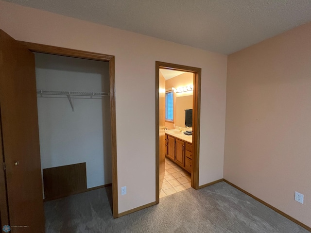 unfurnished bedroom with a closet, baseboards, and light colored carpet