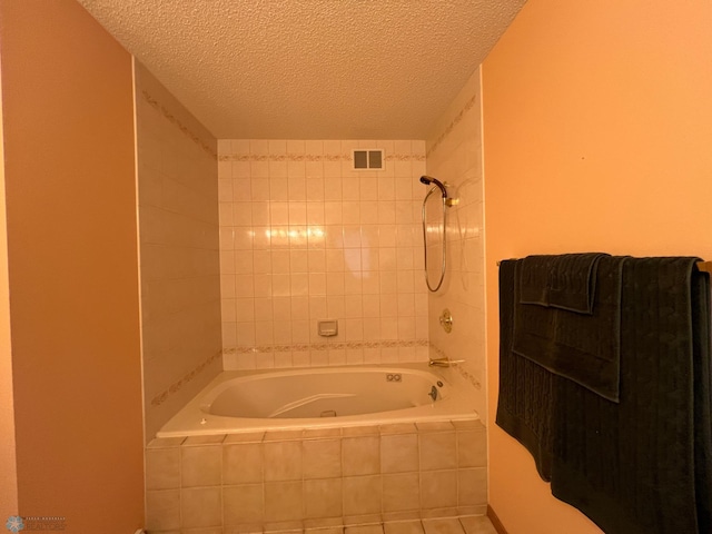 bathroom with visible vents, a textured ceiling, and tiled shower / bath