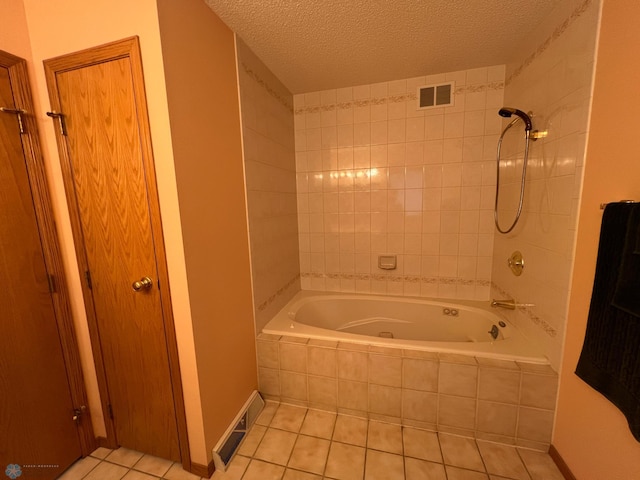 full bath featuring tile patterned floors, tiled shower / bath, visible vents, and a textured ceiling