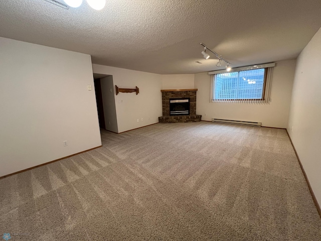 unfurnished living room featuring a baseboard heating unit, a brick fireplace, carpet, and a textured ceiling