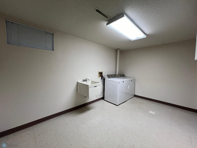 washroom with visible vents, washer and clothes dryer, a textured ceiling, light floors, and laundry area