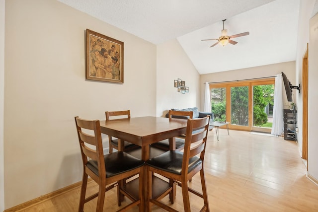 dining space with ceiling fan, baseboards, lofted ceiling, and light wood-style flooring