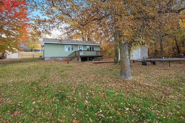 rear view of property featuring a storage shed, a wooden deck, an outbuilding, crawl space, and a yard