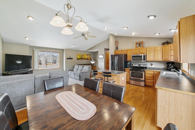 dining space featuring lofted ceiling, light wood-style flooring, and a ceiling fan