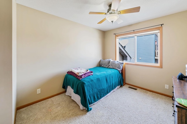 carpeted bedroom with visible vents, a ceiling fan, and baseboards