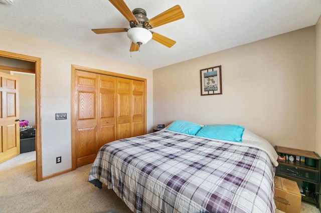 carpeted bedroom featuring a closet, baseboards, and ceiling fan