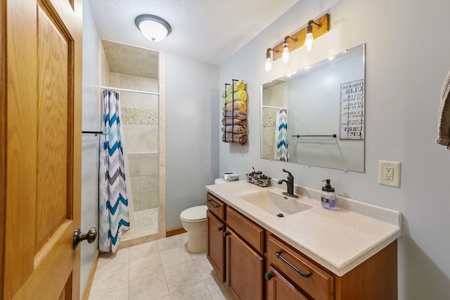 full bathroom with toilet, a tile shower, tile patterned floors, a textured ceiling, and vanity