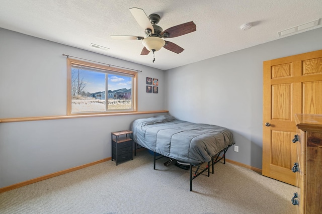 carpeted bedroom with baseboards, visible vents, and a textured ceiling