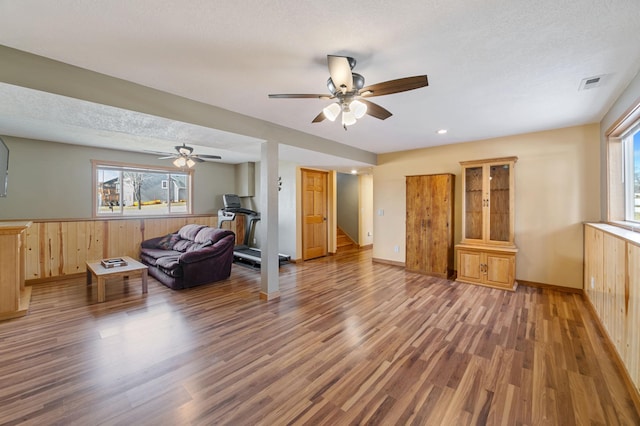 living room with stairs, wood finished floors, visible vents, and a wealth of natural light