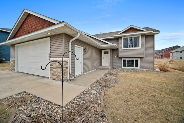 view of front facade featuring driveway, a shingled roof, and a garage