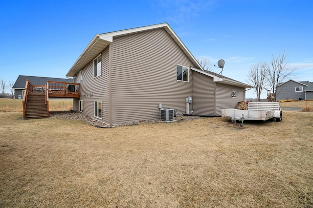 view of home's exterior featuring central air condition unit, a lawn, stairway, and a wooden deck