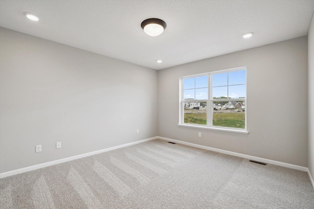 unfurnished room featuring carpet floors, recessed lighting, visible vents, and baseboards