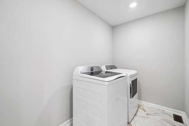 clothes washing area featuring marble finish floor, washer and clothes dryer, visible vents, laundry area, and baseboards