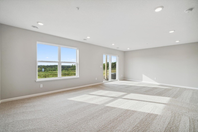 unfurnished room with recessed lighting, baseboards, and light colored carpet