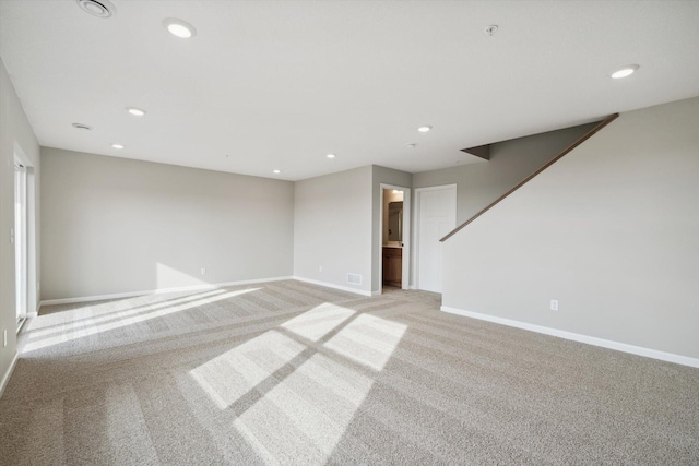 spare room with light carpet, recessed lighting, visible vents, and baseboards