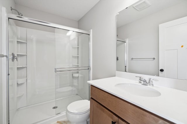 bathroom with toilet, a shower stall, visible vents, and vanity