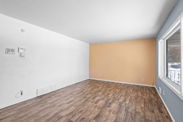 empty room with visible vents, baseboards, and wood finished floors