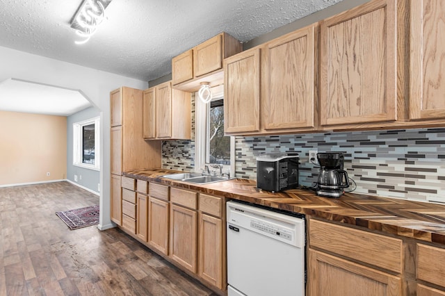 kitchen with decorative backsplash, dark wood-style flooring, white dishwasher, wooden counters, and a sink