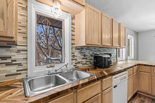 kitchen featuring tasteful backsplash, white dishwasher, a textured ceiling, wooden counters, and a sink