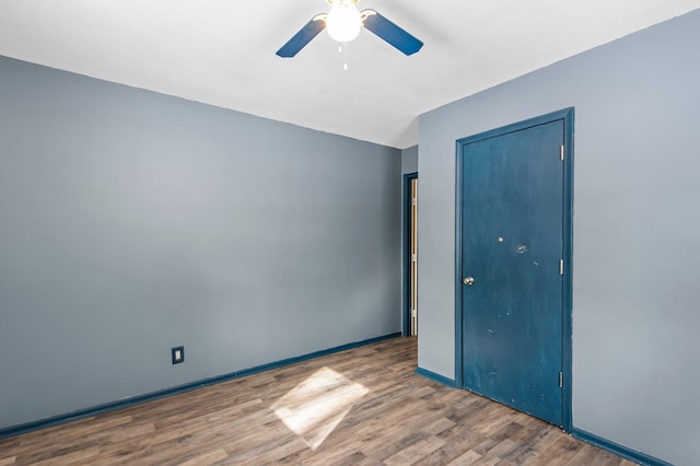 unfurnished room with ceiling fan, baseboards, and wood finished floors