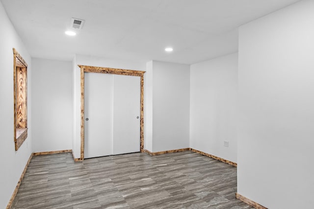 spare room with baseboards, visible vents, wood finished floors, and recessed lighting